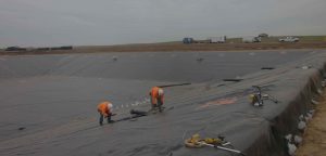 two men installing HDPE pond liner